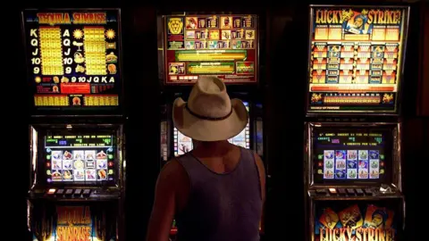 Getty Images A man plays a slot machine 