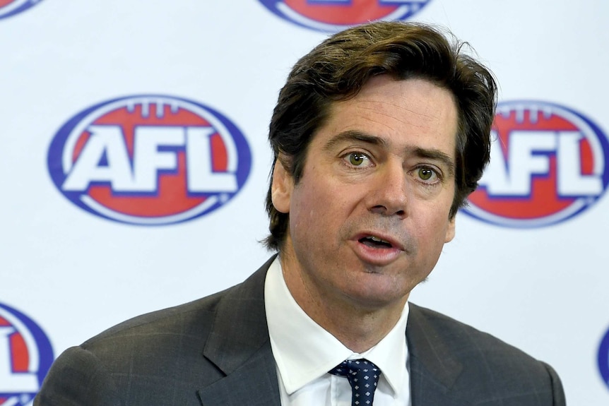 AFL CEO Gillon McLachlan speaks during a media conference in front of a white, red and blue backdrop with the AFL logo on it.